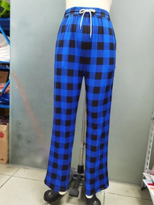 Detail of blue plaid pajama pants featuring an elastic drawstring waistband and straight leg