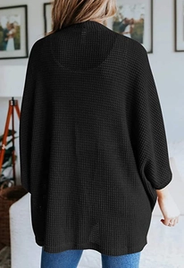 Detailaufnahme der schwarzen Waffelstrick-Struktur bei diesem weiten Damen-Cardigan