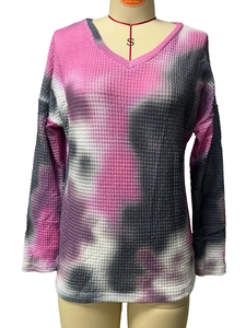Detailed view of pink and grey tie-dye waffle knit fabric on a long sleeve V-neck top