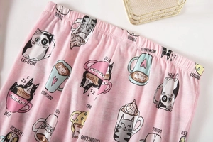 Detailweergave van de roze katoenen pyjamabroek met kat-koffieprint en elastische taille