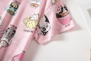 Detailopname van roze gebreide pyjama met schattige kattenkoffieprints en zachte katoenstof