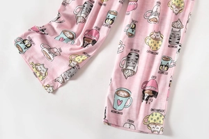 Detail van roze katoenen pyjamabroek met schattige koffiekat-patronen en speelse tekst