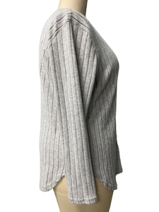 Detail shot of light grey knit fabric featuring vertical ribs and curved side slit hem
