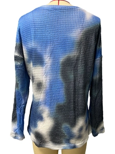 Close-up of blue and black tie-dye waffle fabric texture on a long sleeve V-neck top