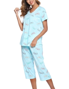 Detail van blauwe pyjamaset met V-hals en kleurrijke vlinderprints op zacht katoen