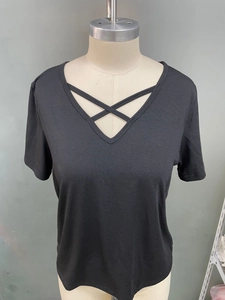 Detail shot of black V-neck t-shirt featuring cross strap design on a mannequin