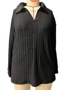 Dettaglio della maglia nera con scollo a V e trama a coste in taglia forte