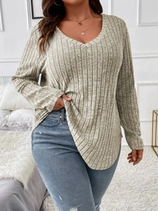 Detail of loose V-neck long sleeve top showing ribbed texture and curved hemline