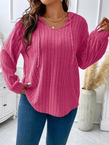 Detail of rose red ribbed knit fabric on a V-neck hooded long sleeve casual top for women