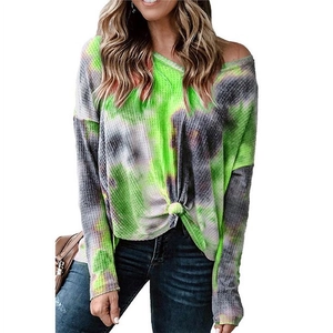 Detail of waffle knit texture and tie-knot hem on tie-dye v-neck long sleeve top