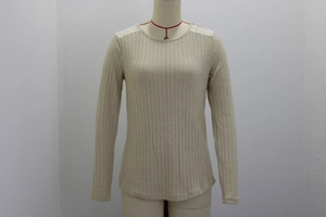 Detalle del tejido de punto acanalado y encaje blanco en el hombro de la blusa de manga larga