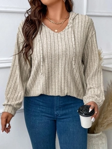Detailed close-up of V-neck hooded knit top with vertical ribbed texture in soft beige gray