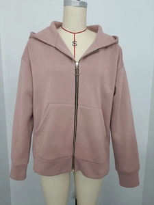 Detail of mauve zip-up hoodie featuring a unique metal circular ring zipper pull