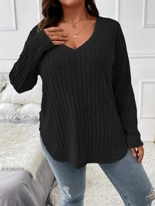 Close-up of black ribbed fabric texture with V-neck and curved hem on plus size top