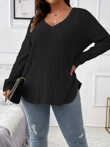 Detail of a women's V-neck ribbed knit top featuring long sleeves and a curved hemline