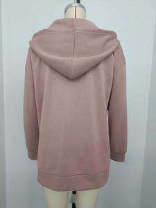 Back view of a loose dusty pink hoodie with ribbed cuffs and drop shoulder detail
