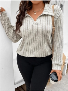 Dettaglio del top in maglia grigio chiaro con trama a costine e colletto a polo con scollo a V