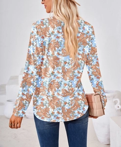 Detalle de la blusa de manga larga azul cielo con estampado paisley y dobladillo redondo