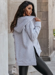 Detail of light grey oversized hoodie featuring side slits and soft cotton blend fabric