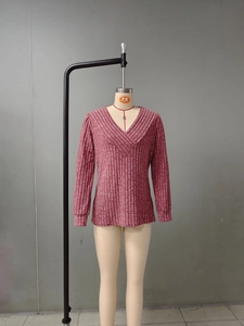 Vue détaillée du pull en tricot côtelé à col en V avec poignets et texture du tissu rose
