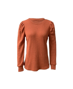 Détail du haut en maille côtelée rouge rouille avec manches bouffantes et poignets larges
