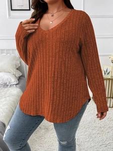 Detail of V-neck ribbed fabric texture on loose orange plus size long sleeve top