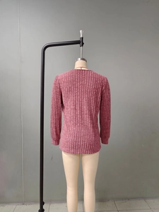 Gros plan du dos d'un pull en maille côtelée rose chiné montrant la texture et les poignets