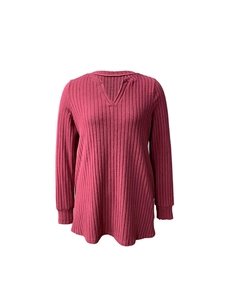 Dettaglio della trama a costine e scollo a V con cinturino sulla maglia in rosa scuro