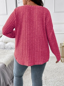Macro shot of rose red ribbed knit texture and curved hem on plus size long sleeve top