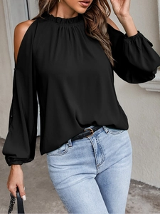 Detail of cold shoulder design and ruffled halter neckline on the black long sleeve top