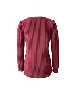 Gros plan d'un haut en tricot bordeaux avec texture côtelée et détails de manches bouffantes