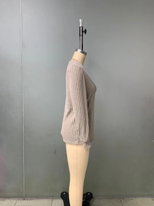 Vue latérale détaillée du haut beige à manches longues côtelé sur un mannequin