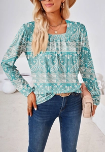 Detalle de blusa bohemia con cuello cuadrado verde azulado, estampado paisley y pliegues