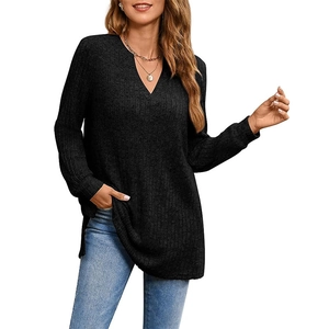 Dettaglio del top nero in maglia a coste con scollo a V profondo e spacco laterale