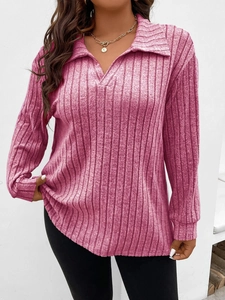 Dettaglio della trama a costine rosa della maglia a maniche lunghe con scollo a V