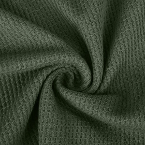 Detailaufnahme von dunkelgrünem Waffelstrickstoff mit Textur und weichen Falten