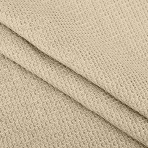 Makroaufnahme von beigem Waffelstrickstoff mit Wabenmuster für Damenoberteile