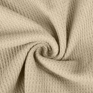 Nahaufnahme der hochwertigen Waffelstrick-Struktur in Beige für Strickpullover-Oberteile