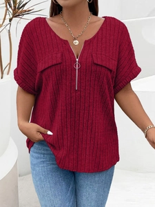 Detail of dark red v-neck zipper top with ribbed knit texture and decorative pockets