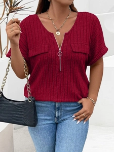 Close-up of wine red ribbed knit fabric with V-neck zipper and decorative front pockets