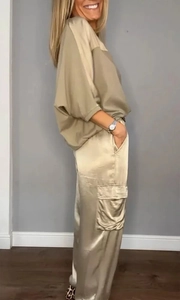Detalle de un conjunto satinado de dos piezas en oro champán con top y pantalón cargo