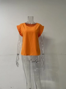 Vista detallada de las mangas cortas con diseño plisado en una blusa naranja de cuello redondo