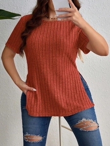 Detail view of ribbed knit rust red t-shirt showing elegant side slit and texture