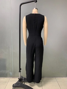 Detail view of black sleeveless wide-leg jumpsuit with back zipper closure and waist tie