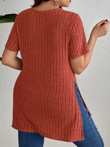 Detail view of brick red ribbed knit short sleeve top featuring side slits and crew neck