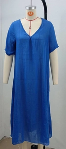 Détail macro du tissu en coton et lin bleu roi et du décolleté en V de la robe ample