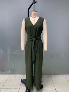 Detail of elegant V-neck sleeveless dark green jumpsuit with waist tie and wide legs