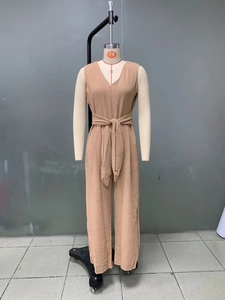 Detail showing the micro-pleated fabric texture and waist belt of the V-neck jumpsuit