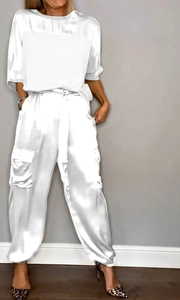 Dettaglio del set due pezzi in raso bianco con top a maniche corte e pantaloni cargo