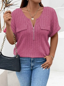 Detail of hot pink ribbed knit top featuring V-neck zipper and decorative pockets